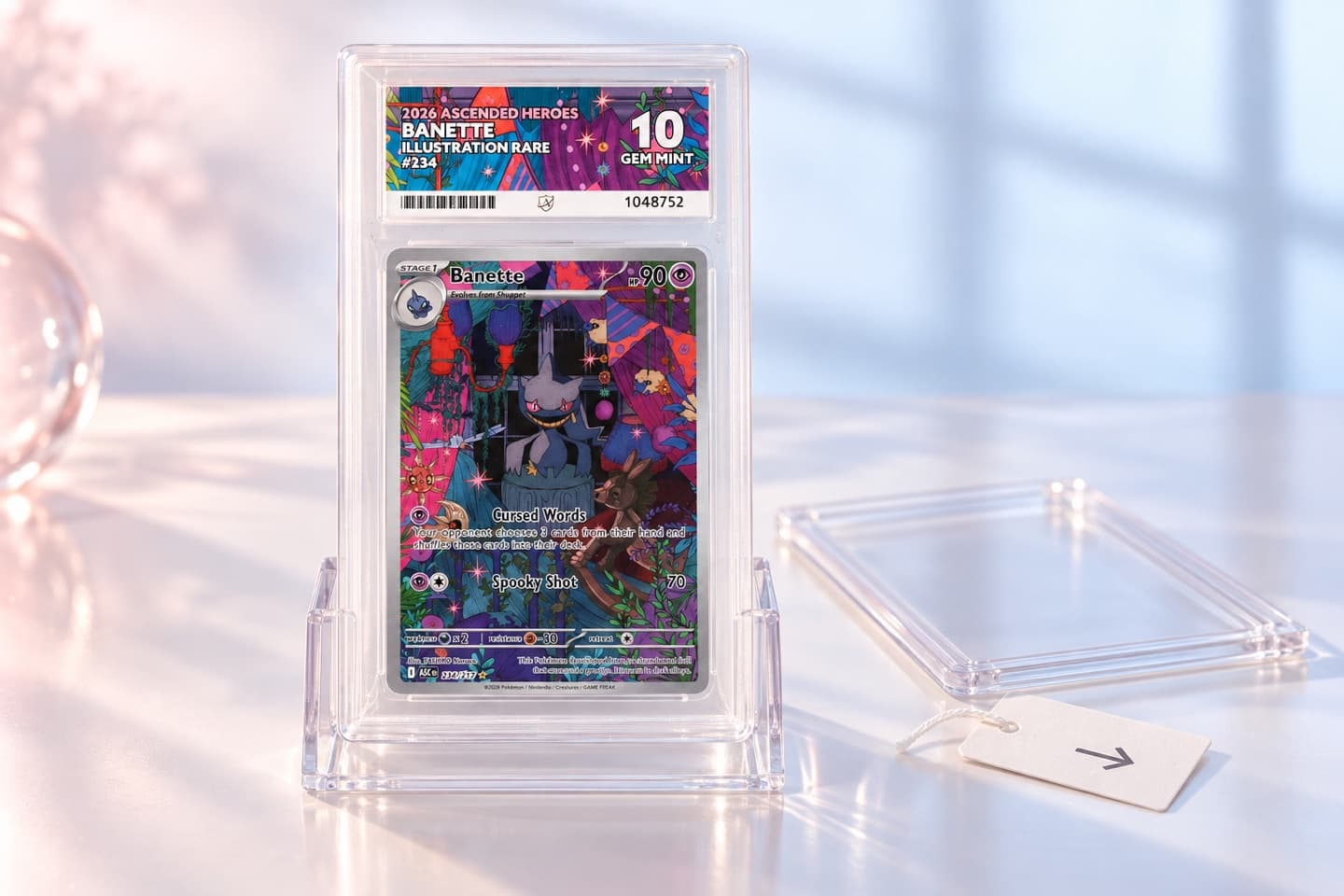 A graded card in its slab on a clear stand, beside a paper tag